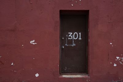 Doorway with number 301 hand-painted onto it and set into well-worn wall