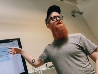 Rob Weychert gesturing at a TV displaying design mockups