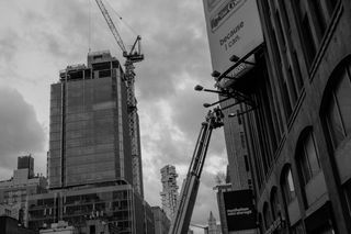 People in a construction lift working on a billboard advertisement