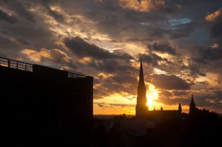 Dramatic cloudy sunset with church steeple in the distance