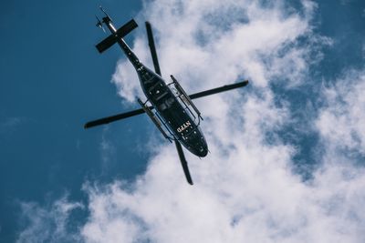 View looking up at the bottom of an NYPD helicopter in flight