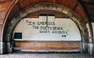 Graffiti on the side of an old wooden archway